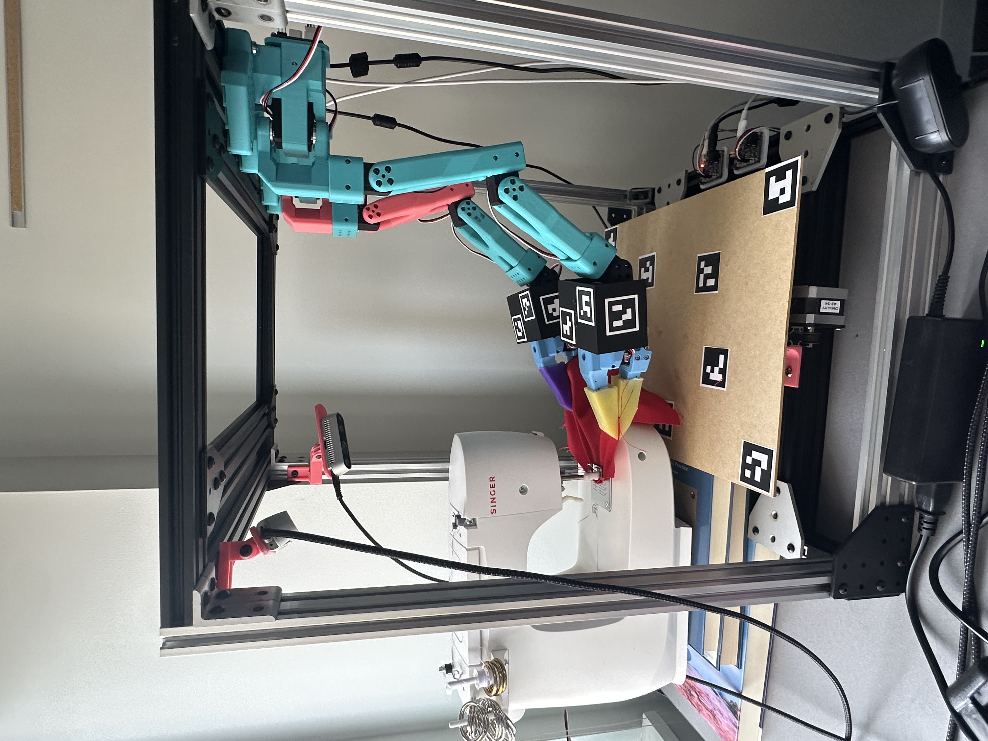 Sewing machine and robot arms — front view